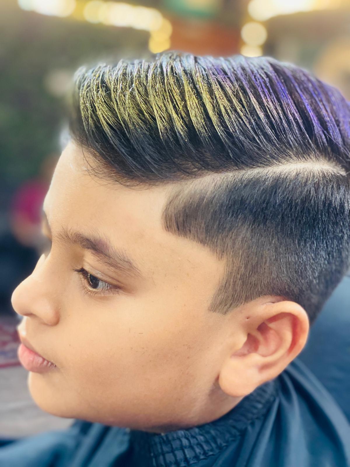 A smiling child getting a neat and stylish haircut from a friendly stylist at Styles and Smiles Unisex Salon.