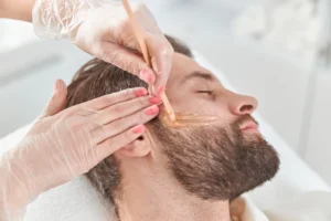 Men receiving a professional face waxing service at Styles 'N' Smiles Unisex Salon, Singapore.